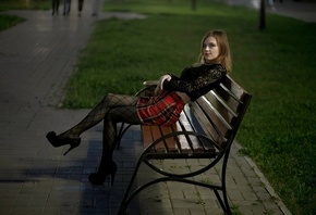 park, women outdoors, public, , blonde, sitting, black blouse, miniskirt, plaid skirt, model, black pantyhose, red lipstick, bench, grass, looking at viewer