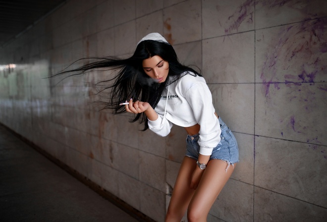 women, brunette, jean shorts, hoods, sweater, black hair, cigarettes, watch, straight hair, smoke, pink nails, closed eyes, wall