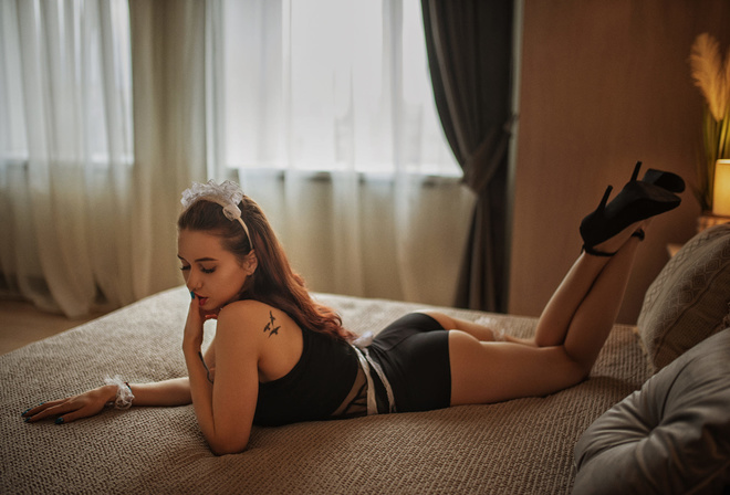 women, high heels, painted nails, in bed, pillow, Black clothes, finger on lips, tattoo, window, women indoors, feet in the air, lying on front, curtains, lamp, nose ring, closed eyes, hair bows