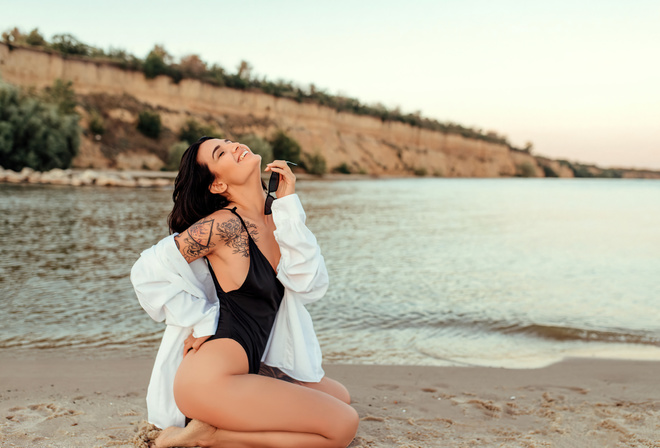 women, kneeling, sand, sunglasses, smiling, one-piece swimsuit, sea, tattoo, white shirt, women outdoors, closed eyes