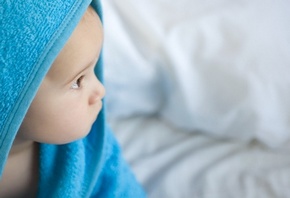 малыш смотрит в даль, в синем полотенце