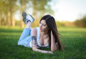 women, Maksim Romanov, grass, sneakers, tattoo, depth of field, pants, jeans, lying on front, women outdoors, piercing