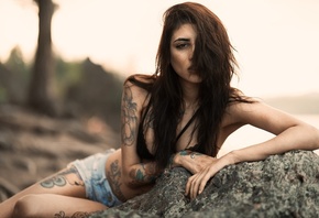 women, brunette, tattoo, hair in face, jean shorts, depth of field, women outdoors, rocks, bikini top