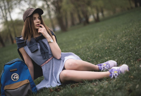 women, baseball caps, dress, sitting, finger on lips, women outdoors, trees, grass, looking away, handbags, depth of field