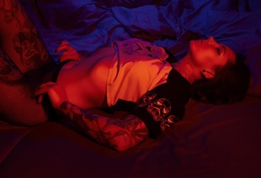 women, fishnet stockings, closed eyes, in bed, black nails, belly, pierced navel, lying on back, eyeliner, neon