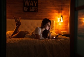 women, ass, in bed, T-shirt, feet in the air, panties, lamp, lying on front, cellphone