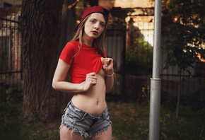 women, jean shorts, women outdoors, baseball cap, red t-shirt, crop top, trees, pierced navel