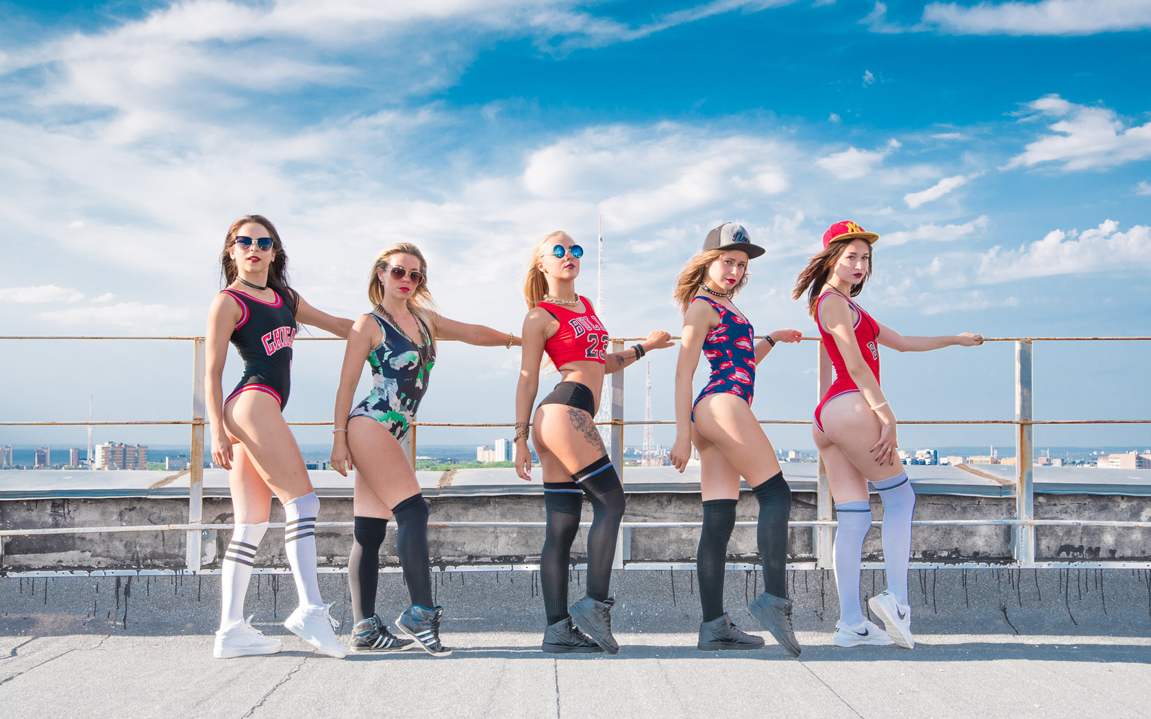 group of women, blonde, ass, brunette, sunglasses, pale, white stockings, black stockings, sneakers, one-piece, long hair, baseball caps, tattoos, looking at viewer, sky, clouds, choker, necklace, t-shirt, short shorts, cityscape