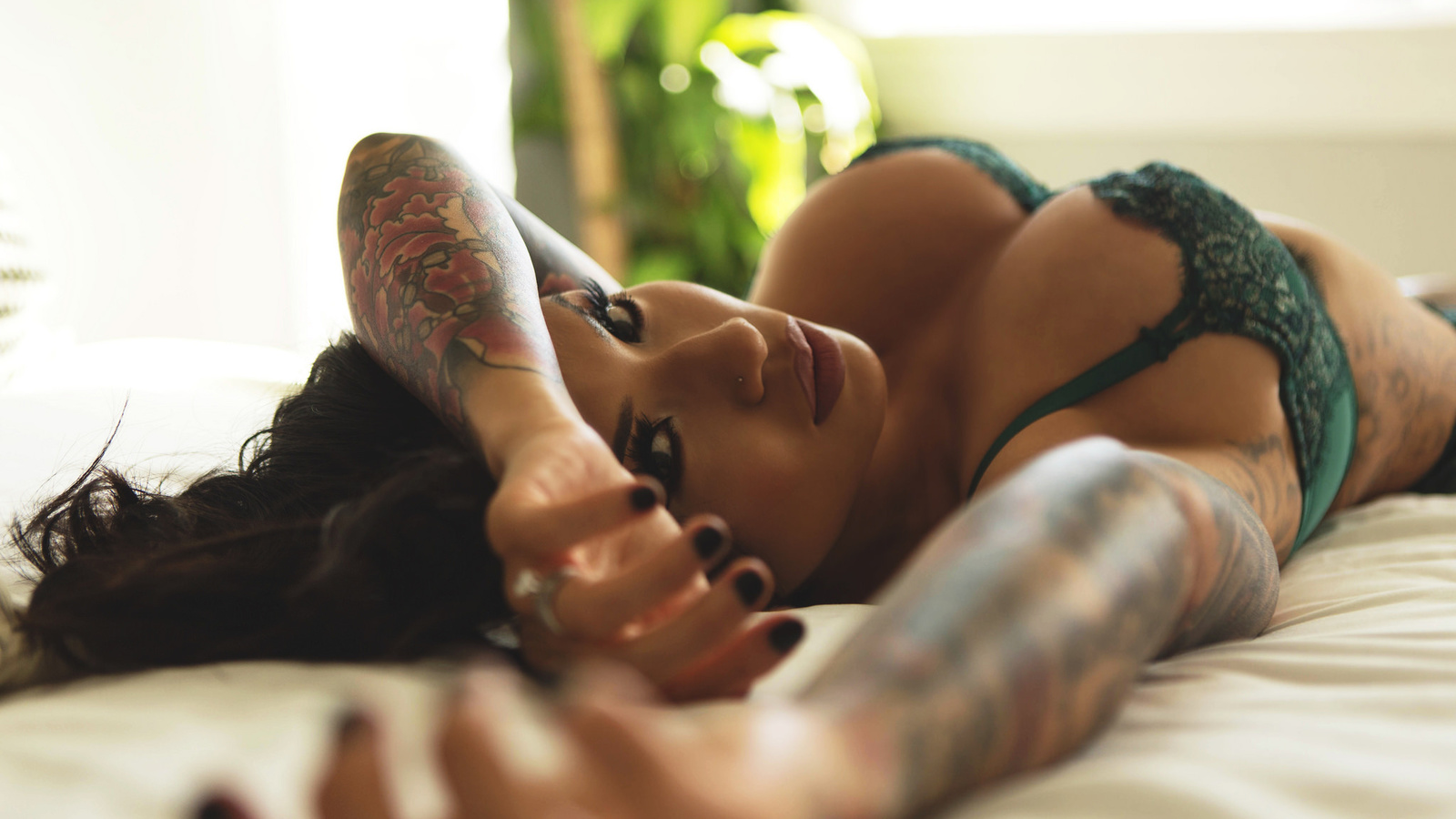 women, green lingerie, tattoo, in bed, armpits, lying on back, looking at viewer, pierced nose, depth of field, ,  , ,  ,   ,   ,  
