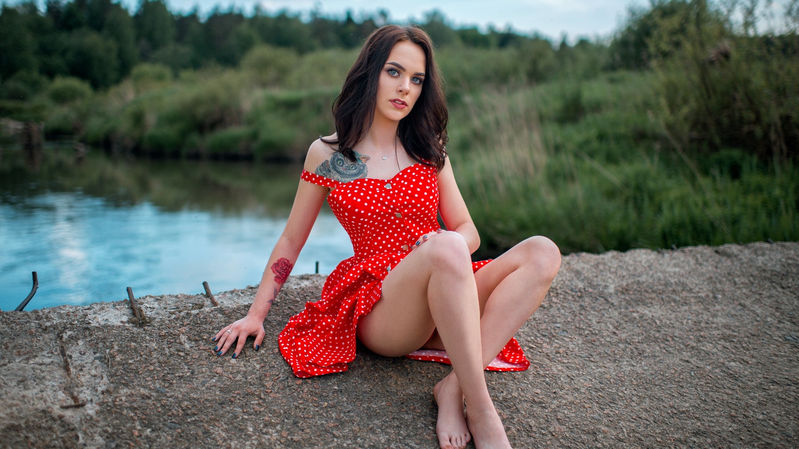 women, red dress, polka dots, women outdoors, tattoo, sitting, ass, blue nails, river, bare shoulders, pierced nose, gray eyes, red lipstick