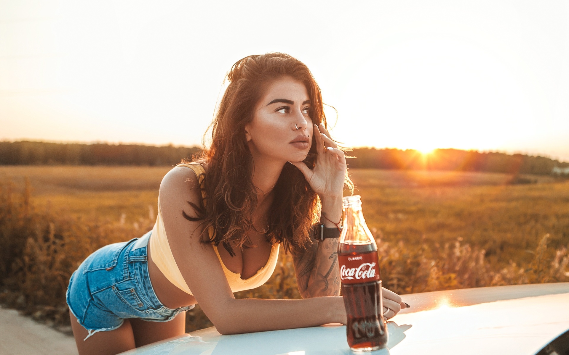 women, brunette, women outdoors, women with cars, nose ring, jean shorts, bottles, coca-cola, piercing, looking away, juicy lips, sunset, tank top, tattoo, watch