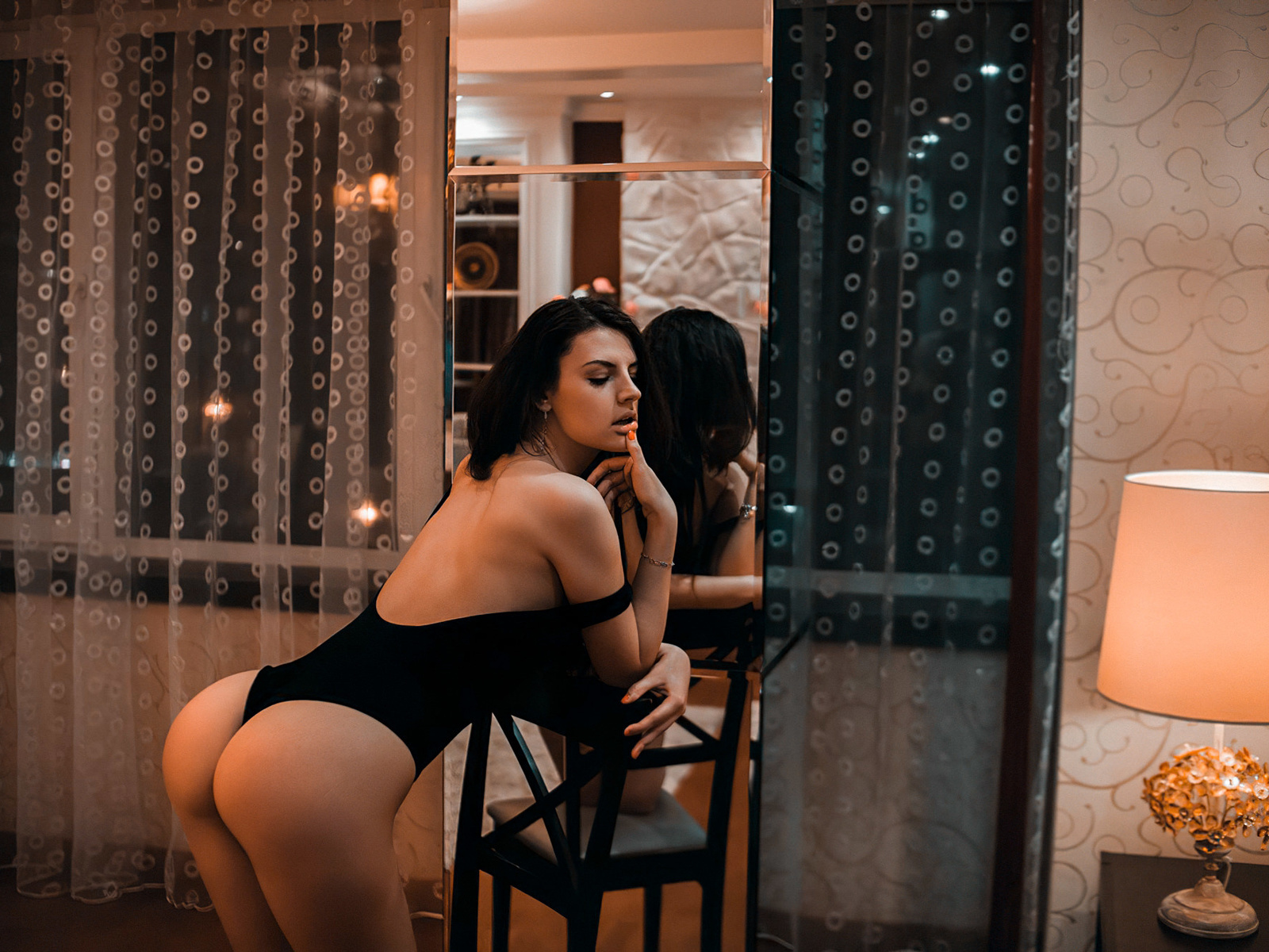 women, ass, lamp, mirror, reflection, window, bodysuit, finger on lips, women indoors, painted nails, chair
