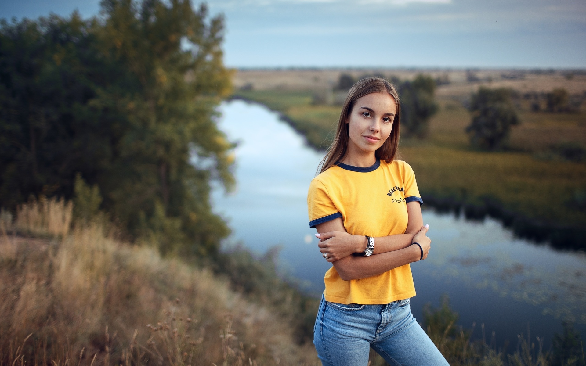 women, yellow t-shirt, river, nature, jeans, watch, arms crossed, sky, women outdoors, smiling