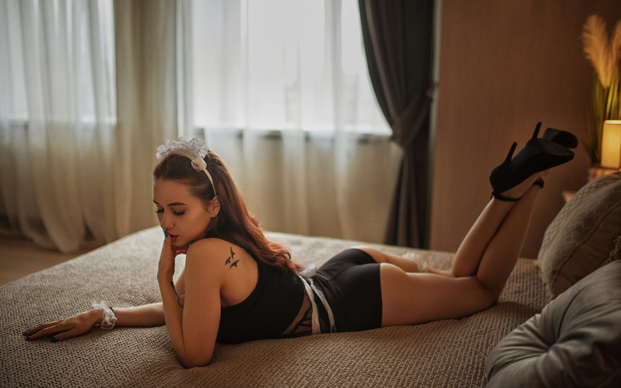 women, high heels, painted nails, in bed, pillow, black clothes, finger on lips, tattoo, window, women indoors, feet in the air, lying on front, curtains, lamp, nose ring, closed eyes, hair bows