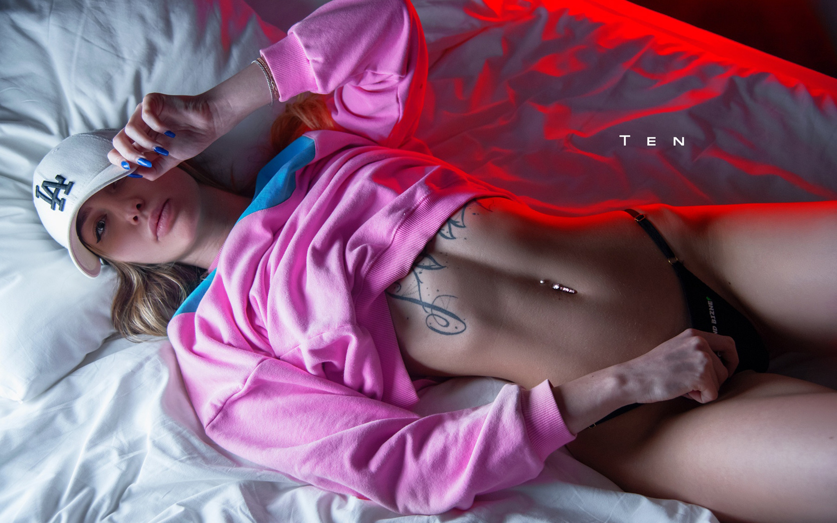 women, alexander ten, baseball cap, black panties, tattoo, in bed, pink lipstick, pink sweater, blue nails, belly, pierced navel, top view, hips