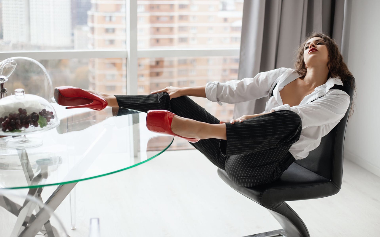 model, brunette, pants, red shoes, high heels, office, chair, suspenders, window, sitting, glass table, grapes, makeup