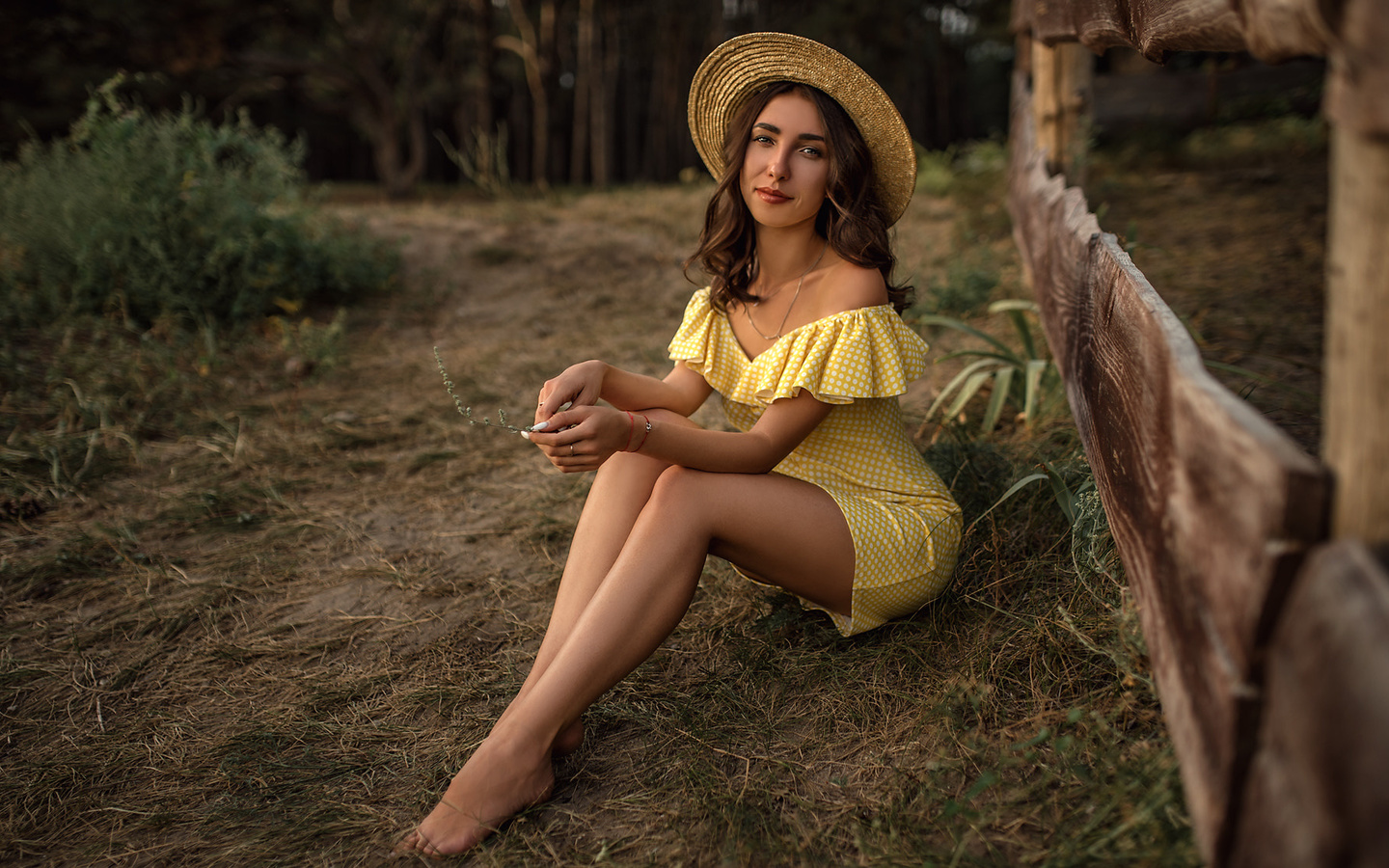 women, skinny, yellow dress, women outdoors, brunette, polka dots, hat, fence, necklace, smiling, trees, sitting