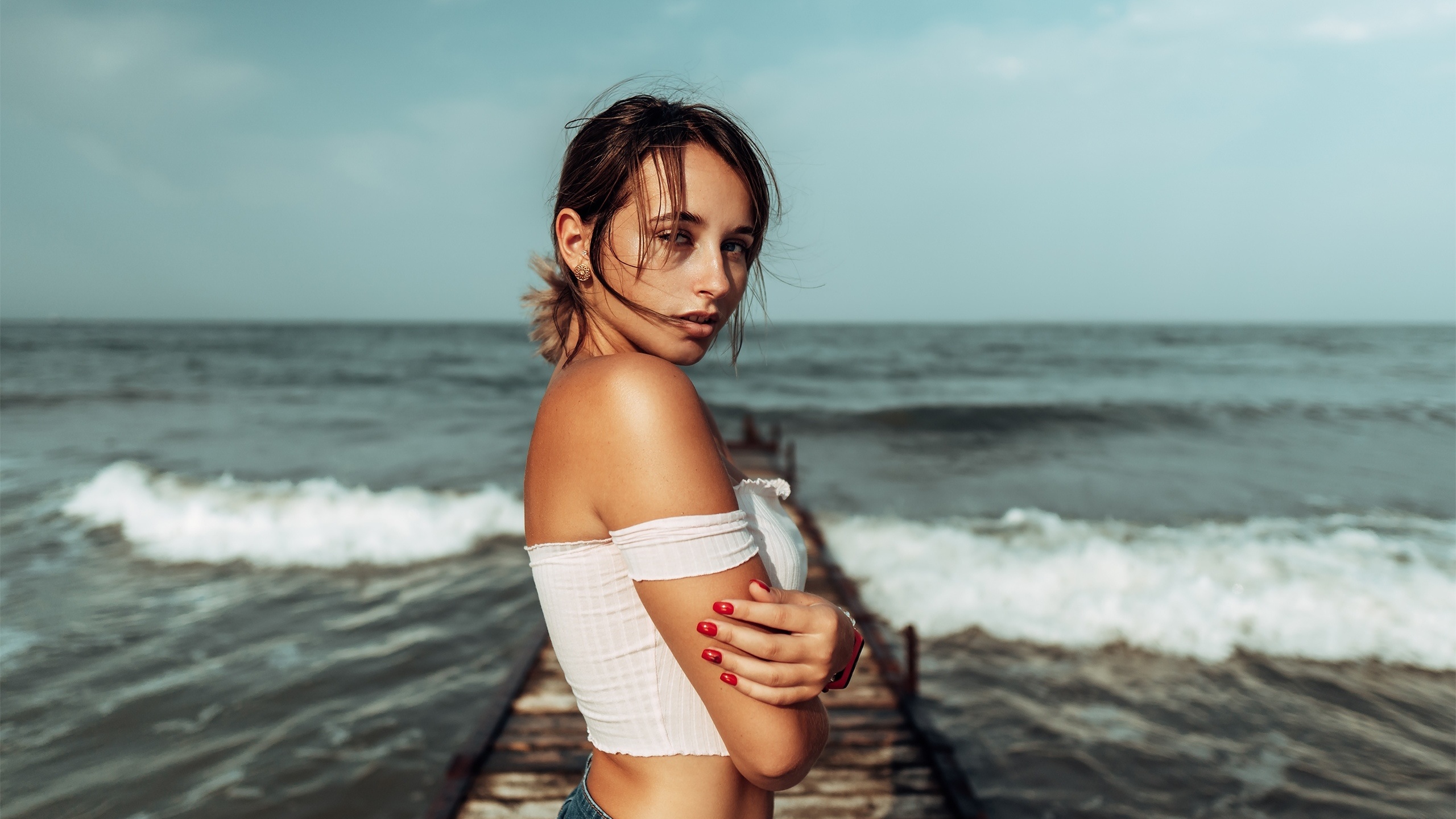 women, brunette, sea, women outdoors, jean shorts, red nails, pier, bare shoulders, watch, arms crossed, sky